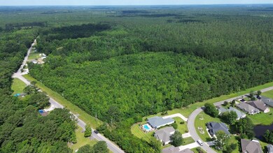Aerial view of property and surrounding area with a heavily wooded area
