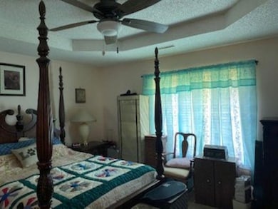 Bedroom featuring multiple windows, a textured cei