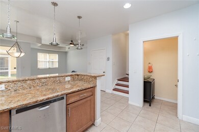 Kitchen featuring light stone counters, dishwasher