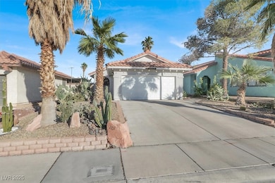 Mediterranean / spanish house with driveway, stucco siding, a tile roof, and a garage