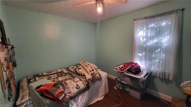Hardwood floored bedroom featuring ceiling fan