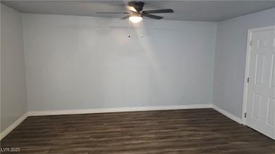 Empty room featuring dark wood finished floors, ba