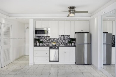 This stylish kitchen combines contemporary design with everyday functionality. Featuring crisp white cabinetry, elegant black stone countertops, and a striking mosaic tile backsplash, the space exudes modern sophistication. The high-end induction cooktop offers precise temperature control and energy efficiency, complemented by stainless-steel appliances and a deep chrome sink. Beautifully updated culinary space — perfect for both cooking and entertaining.