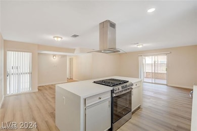 Kitchen with gas stove, island range hood, light w