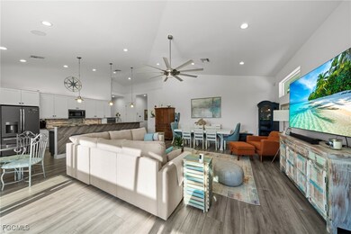 Living room with a ceiling fan, wood finished floors, recessed lighting, and high vaulted ceiling