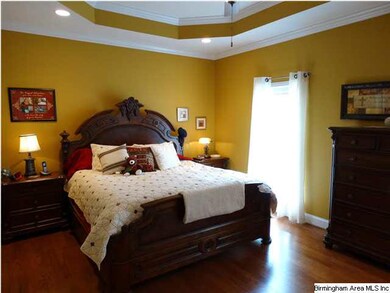 Master bedroom has hardwood floors and tray ceilin