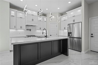 Kitchen with a sink, white cabinets, marble finish floor, stainless steel fridge, and custom range hood