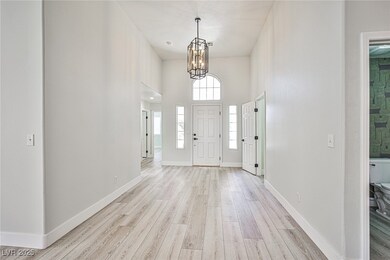 Foyer with light wood-type flooring, a chandelier,