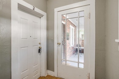 Doorway to outside featuring a textured wall and light wood finished floors
