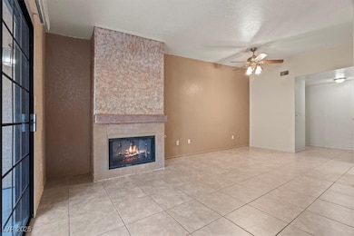 Unfurnished living room featuring a tiled fireplac