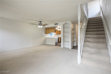 Unfurnished living room featuring ceiling fan, a t
