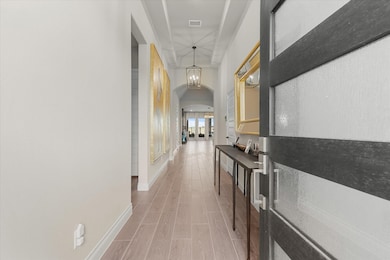 The long hallway leads to an open living area 