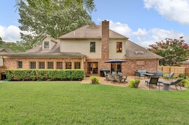 The home is wrapped in windows, grass, and garden.