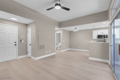 Unfurnished living room featuring baseboards, ligh