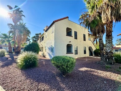 View of side of property featuring stucco siding, a tile roof, and stairway