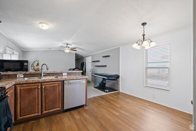 Bright and functional layout with laminate wood flooring, ample cabinet space, and a bar-height counter perfect for casual dining or entertaining. The adjoining dining area enjoys natural light and modern lighting.