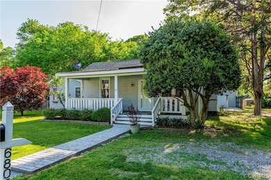 Bungalow-style house with a front lawn and covered porch