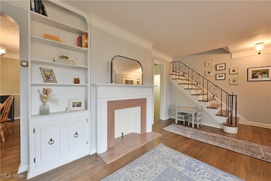 Living room with dark wood-style floors and stairs