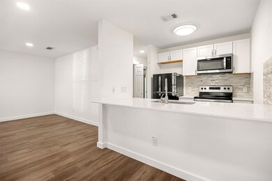 Kitchen with wood finished floors, a sink, stainl