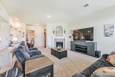 Living room with electric fireplace, bar area that opens to kitchen