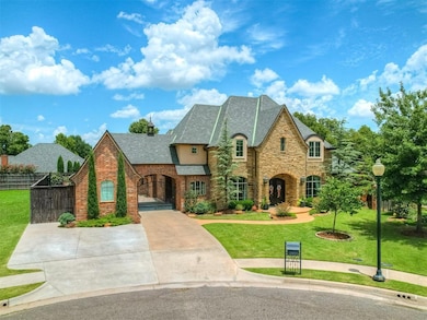 French country style house with stone siding, a gate, and concrete driveway