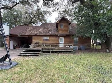 Back of house featuring a deck and a lawn