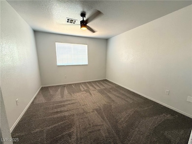 Empty room with carpet, a ceiling fan, and a textu
