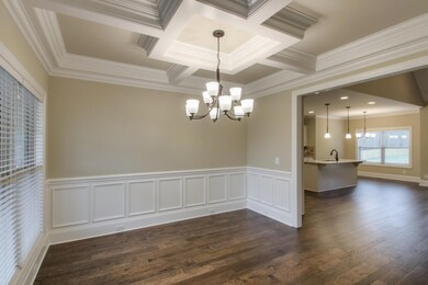 Dining room of foyer features coffered ceilings and wainescotting trim detail.