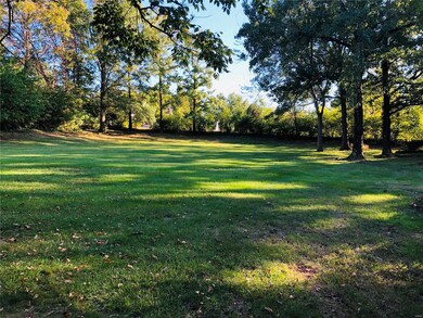 The large level backyard surrounded by mature trees provides a private oasis.