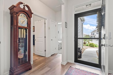 Entryway with baseboards, visible vents, and wood finished floors
