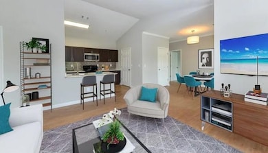 Living area with light wood-style flooring, crown 
