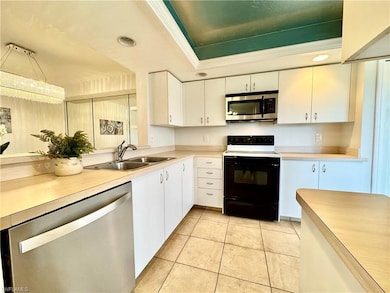 Kitchen with sink, white cabinetry, light tile pat
