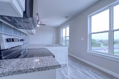 Kitchen featuring sink, light stone counters, rang