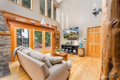 Living room with water view, vaulted ceiling and beautiful log pillars. Walks out onto wrap-around trex deck.