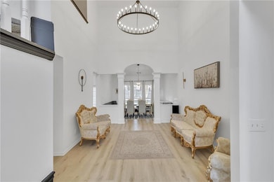 Living area with wood finished floors, a towering 