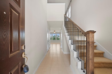 Foyer entrance with baseboards, light tile patter