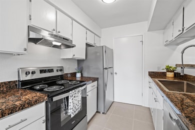 Kitchen featuring under cabinet range hood, stain