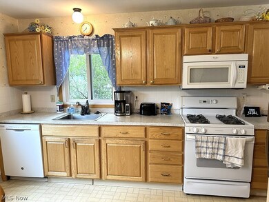 Kitchen with sink, tasteful backsplash, and white appliances