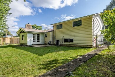 Rear view of house with french doors and a lawn