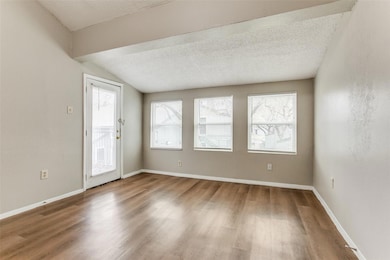 Spare room featuring baseboards, lofted ceiling, w