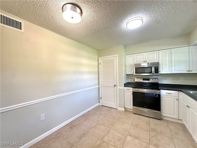 Kitchen with light tile patterned floors, a textur