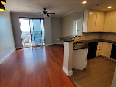 Kitchen with tasteful backsplash, kitchen peninsula, dark hardwood / wood-style flooring, sink, and ornamental molding