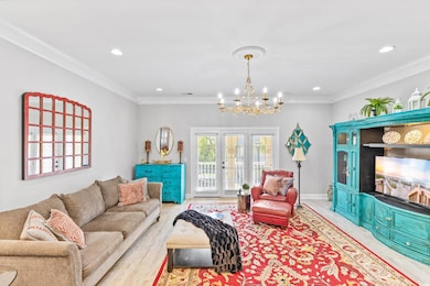 Living room featuring crown molding, light hardwoo