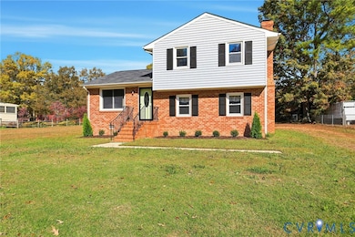 Tri-level home featuring brick siding and a chimney