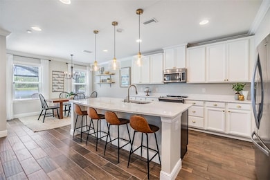 Crisp, white kitchen with designer pendent lighting