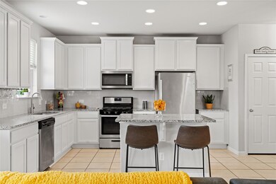 Kitchen with light tile patterned flooring, a sin