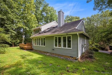 Rear view of property with a deck and a yard