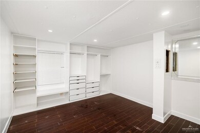 Primary bedroom has wood look tile and built in cabinets.