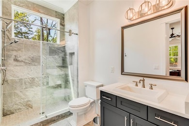 Bathroom with an enclosed shower, vanity, toilet, 
