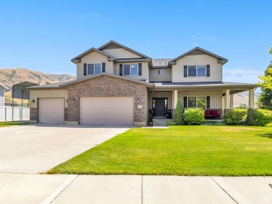 2 story home with a garage, concrete driveway, covered porch, stone siding, and board and batten siding